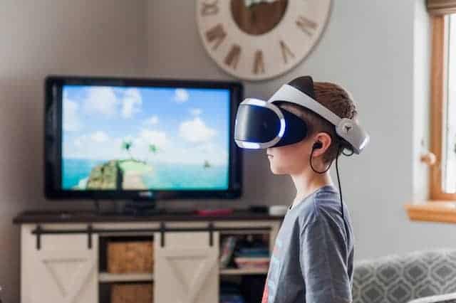 A boy using a vr headset while watching TV.