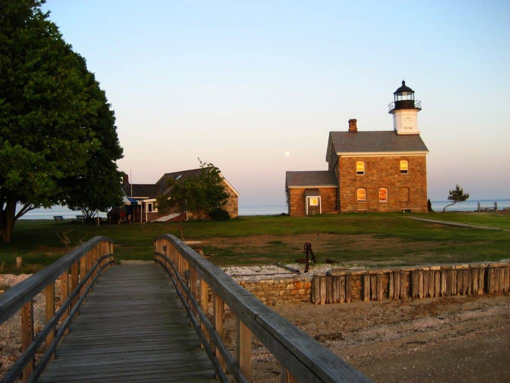 A picturesque wooden walkway leading to a charming lighthouse.