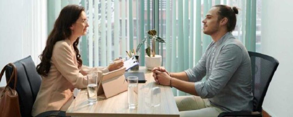 A man and woman showcasing resume gems at an office table.