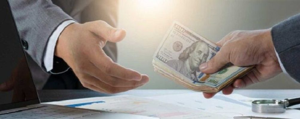 Two businessmen exchanging money as a part of their deal.